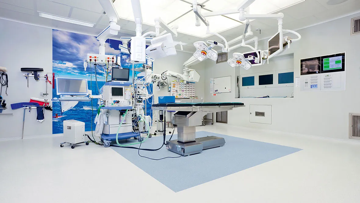 Bright surgical suite with operating table, patient monitor and medical equipment