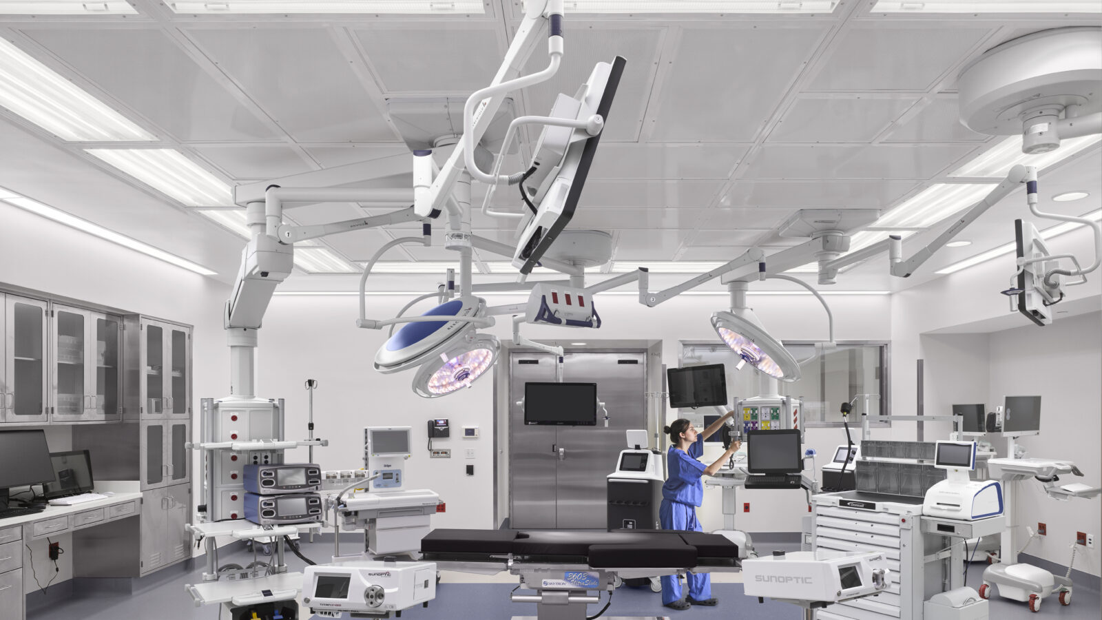 Modern operating theatre with integrated surgical equipment and ceiling-mounted lights